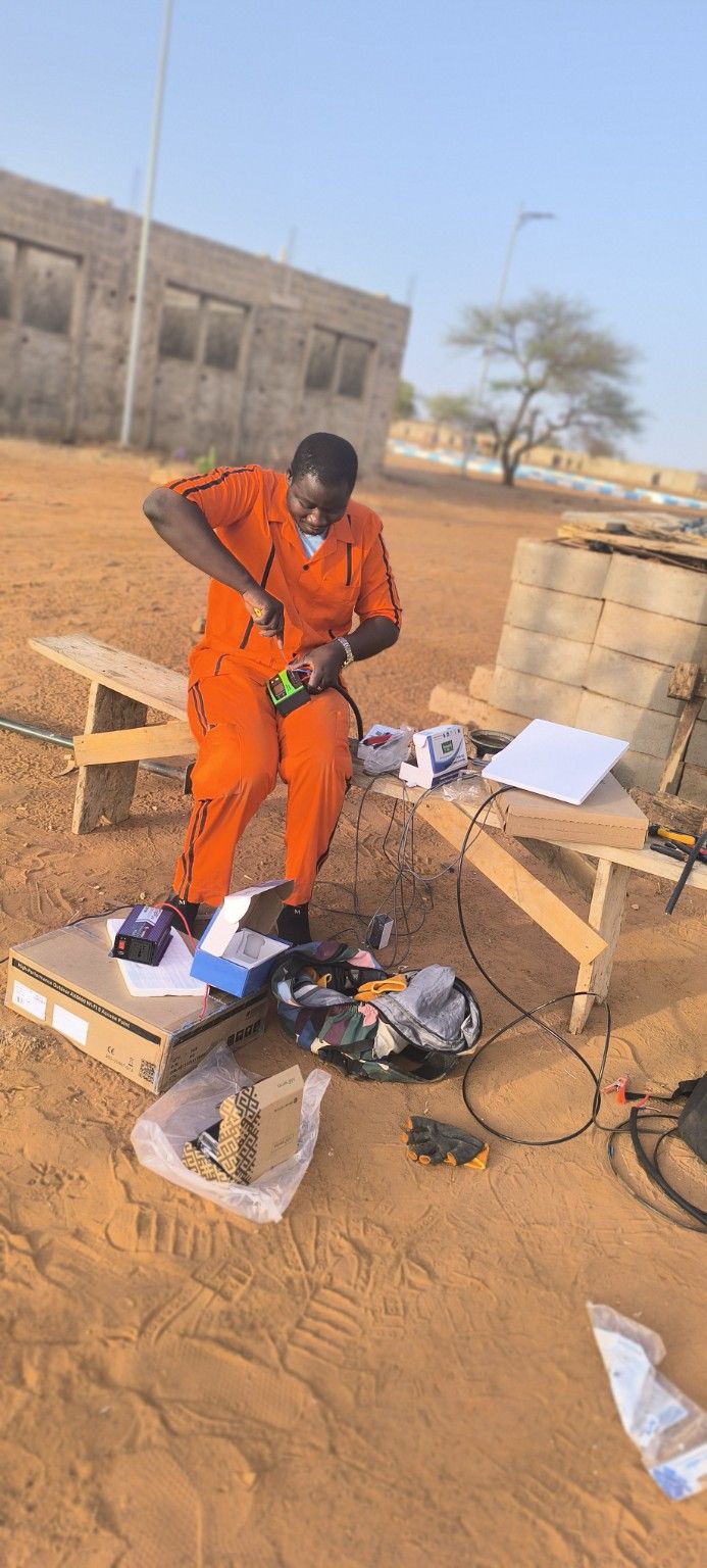 Technicien NICRESI préparant un point d'accès Wi-Fi et un convertisseur sur un chantier
